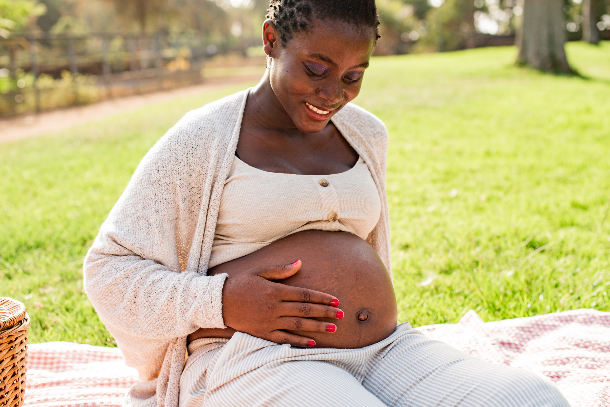 Happy pregnant black woman touching belly
