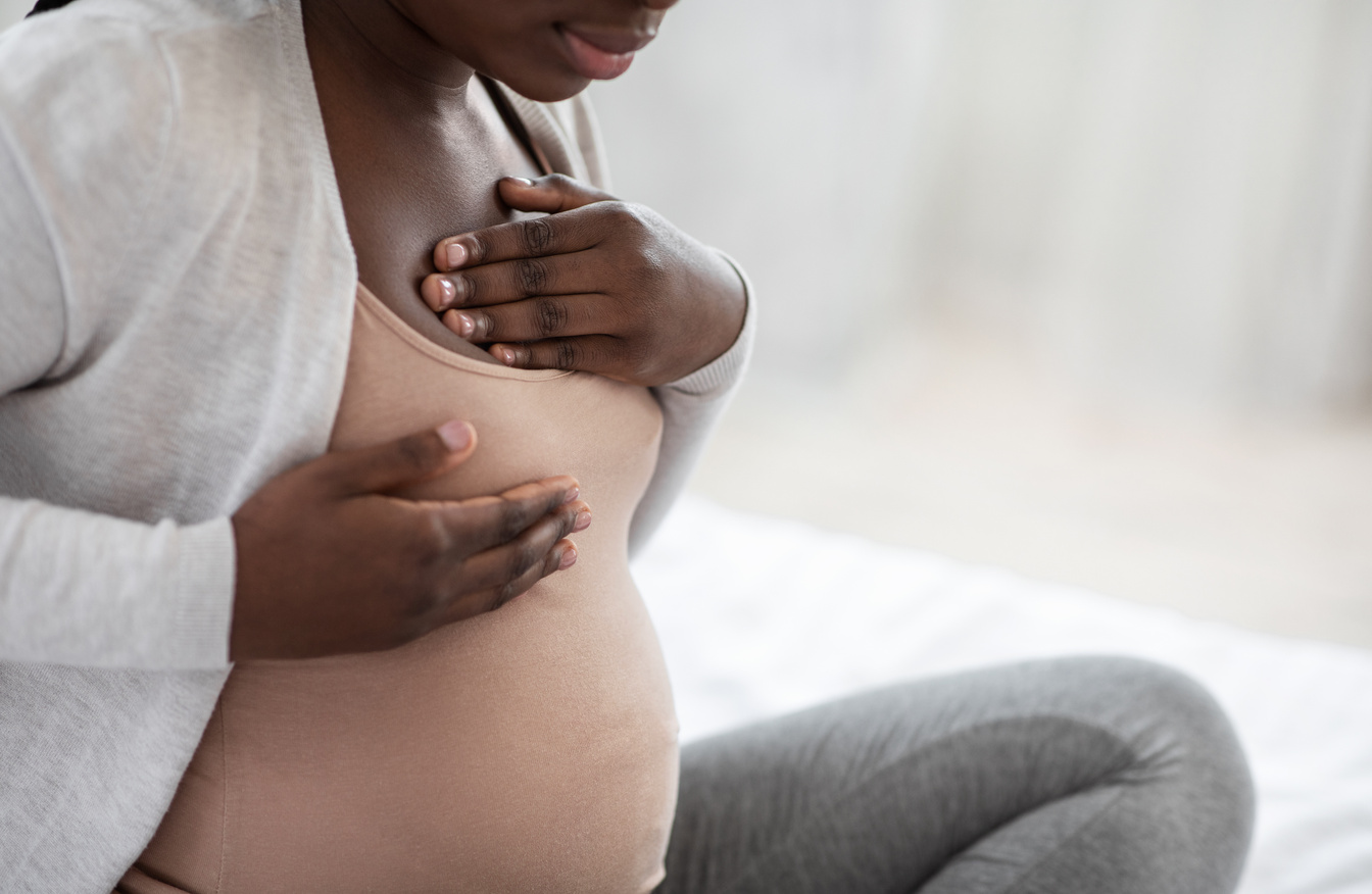 Pregnancy Discomfort. Black pregnant woman suffering painful feelings in breast, massaging herself